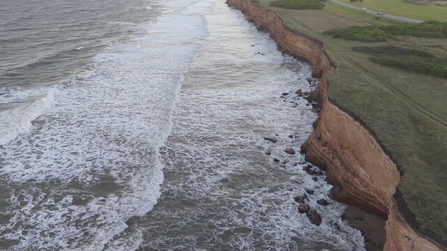 Orilla del mar con olas chocando contra acantilado, naturaleza costera vista cenital a&eacute;rea