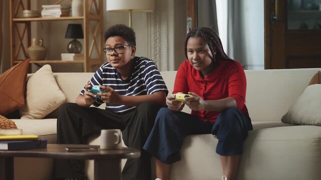 Two siblings celebrating a video game victory and giving each other a high five