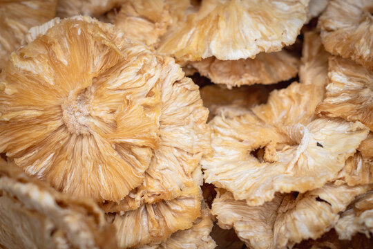 Full frame background of dried pineapple rings, delicious sweet dehydrated tropical fruits texture.