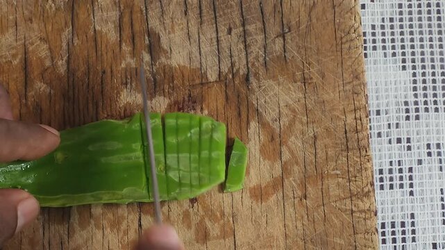 Slicing Fresh Green Nopal Cactus Pad on Rustic Wooden Table Close Up