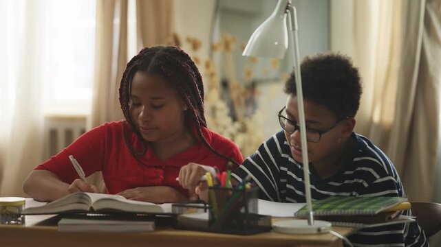 African American children finishing homework and giving each other a high five