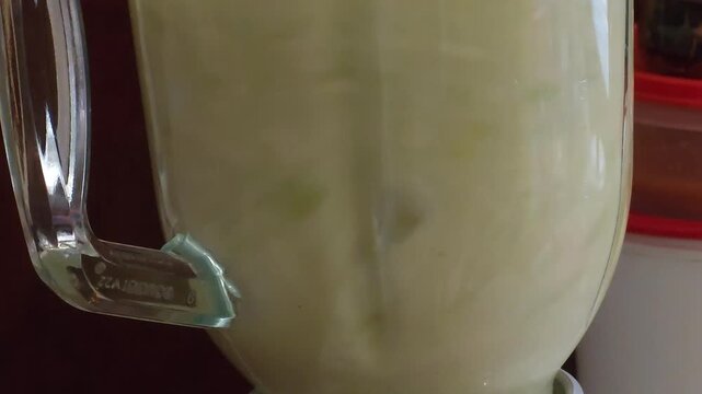 Electric Blender Mixing Fresh Banana, Apple and Nopal Cactus for Green Smoothie