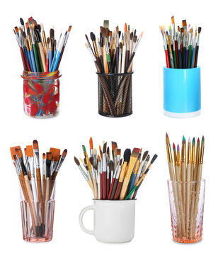 Different paint brushes in holders isolated on white, set