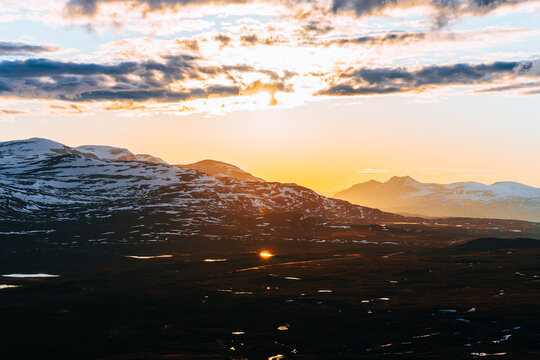 Midnight sun over snow covered mountains during Midsummer in Finland