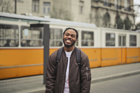 Happy young Black man smiling on a city street