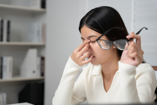 Eye problems, Asian women with tired and irritated eyes, eye rubbing, dry, eye pain after work, migraine, headache, blurred vision, photophobia, working in the dark, blue light from computer