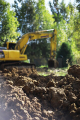 Excavator in Action: Construction Site Earthmoving Under Sunny Skies