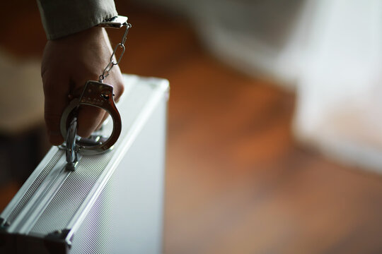 Handcuffed Hand Holding Metal Briefcase - Crime, Security, Law Enforcement, Investigation, Business