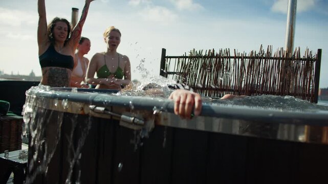 The plunge turns social as friends cheer beside the outdoor spa tub