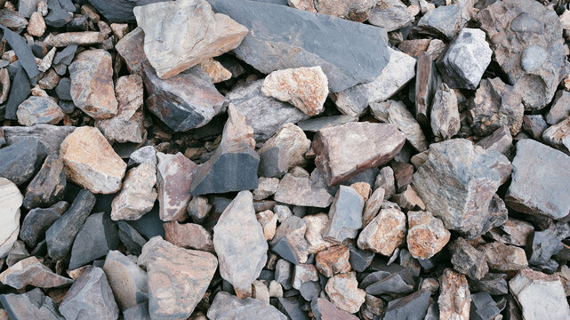 Stones of different sizes in the bay. Pebbles and stones on the beach, background texture.