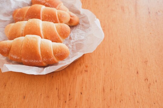 Four pieces of salt bread in a basket, cafe breakfast image with copy space