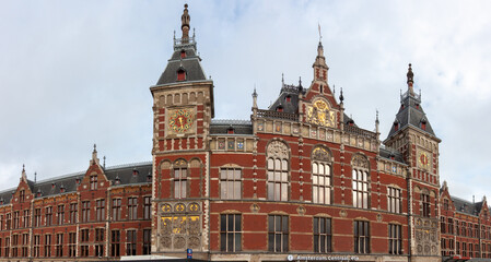 Obraz premium Amsterdam Centraal railway station building in the Netherlands under cloudy sky