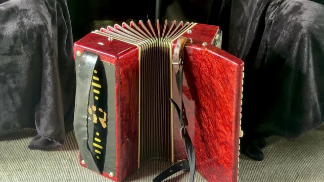 Vintage Accordion's Charm: A close-up of a vintage, red wooden accordion, its bellows partially open, hinting at the melodies it holds within.