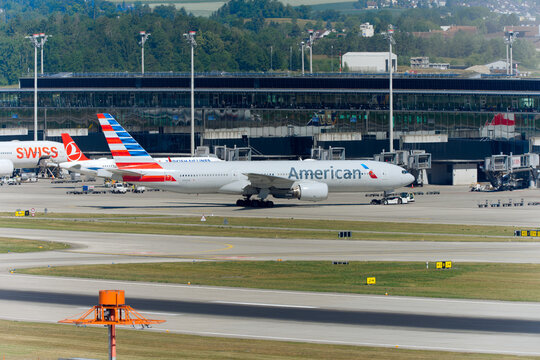 Pushback American Airlines passenger airplane type Boeing 777-223(ER) registration N766AN leaving Swiss Z&uuml;rich Airport on a sunny spring day. Photo taken June 14th, 2026, Zurich Kloten, Switzerland.