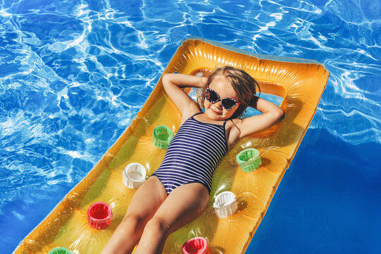 Child in swimming pool. Having fun on vacation at the hotel pool. Colorful vacation concept.