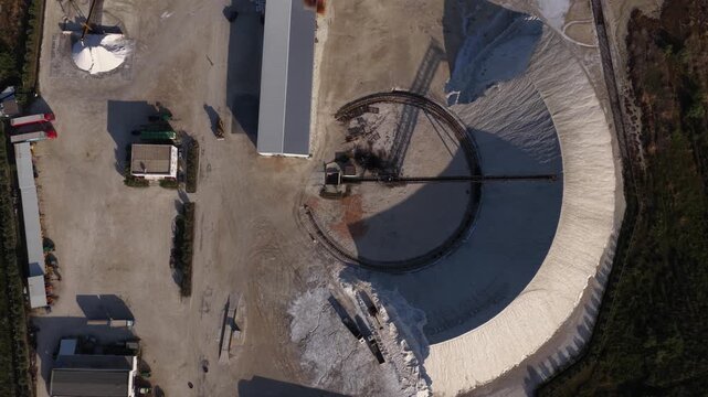 Aerial view of industrial salt piles and machinery at the Narta Lagoon saltern facility in Vlore, Vlore County, Albania.