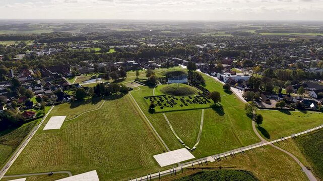 Aerial drone view of Jelling Church, Viking burial mounds, and surrounding town within UNESCO heritage landscape in Denmark