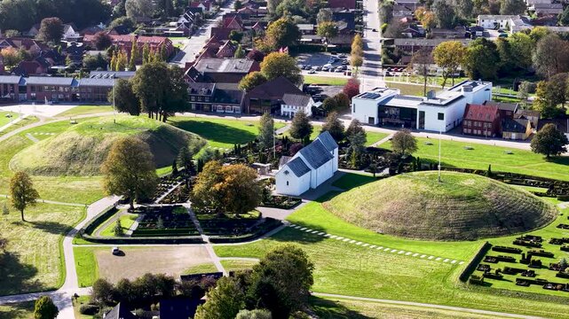Aerial drone view of Jelling Church and Viking burial mounds within UNESCO World Heritage landscape in Denmark