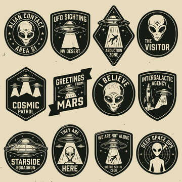 Collection of vintage monochrome alien and UFO themed badges.