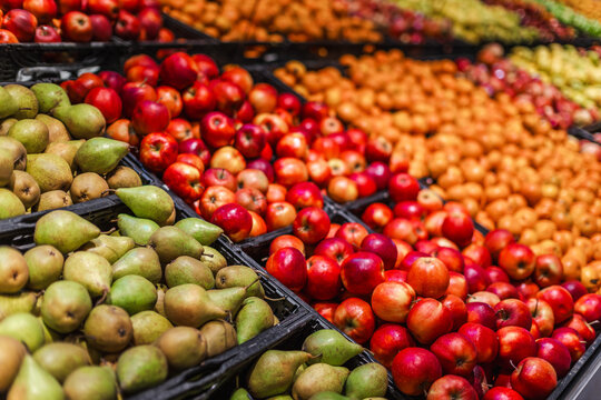 Colorful assortment of fresh apples and pears at supermarket produce department