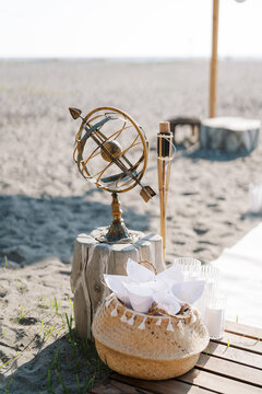 Decorative Armillary Sphere and Basket on Sandy Beach