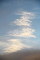 Obraz premium Sky with soft cirrus clouds illuminated by warm light blue upper sky and darker gray lower clouds typical of sunset or sunrise