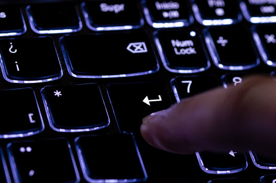 Close-up of finger presses the input key on the blue keyboard. Selected focus.