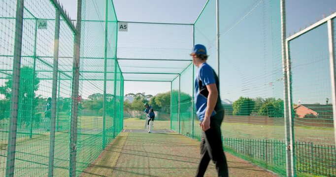 Asian batsman reacting to bowler delivering red ball advancing, swinging bat in practice net