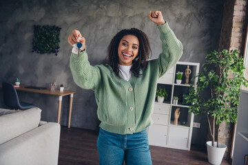 Photo of nice young girl hold key house winning wear green knitted clothes enjoy modern cozy...