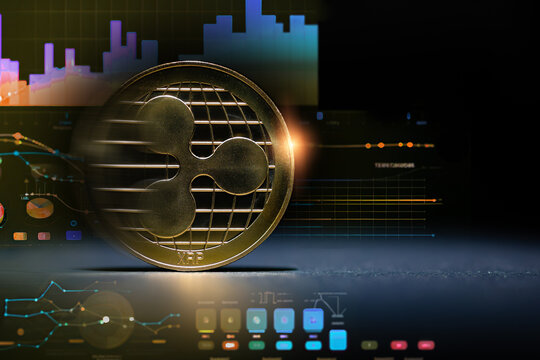  Criptomonedas y tecnolog&iacute;a.Monedas de oro XRP Ripple sobre un fondo de gr&aacute;ficos burs&aacute;tiles abstractos y futuristas. Concepto de finanzas e inversi&oacute;n.