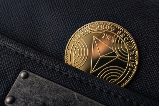  Criptomonedas y tecnolog&iacute;a.Monedas de oro TRX con billetera, primer plano.Acumulaci&oacute;n de Bitcoin, concepto de comercio, venta y compra.