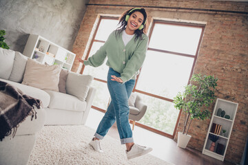 Fototapeta premium Full length photo of lovely young girl headphones dancing have fun dressed green knitted garment spacious house indoors room