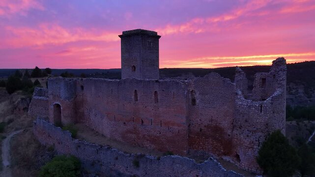 Aerial view from a drone of the sunset at the castle in the town of Ucero, in the Burgo de Osma region, Soria Province, Autonomous Community of Castile and Leon, Spain. Europe