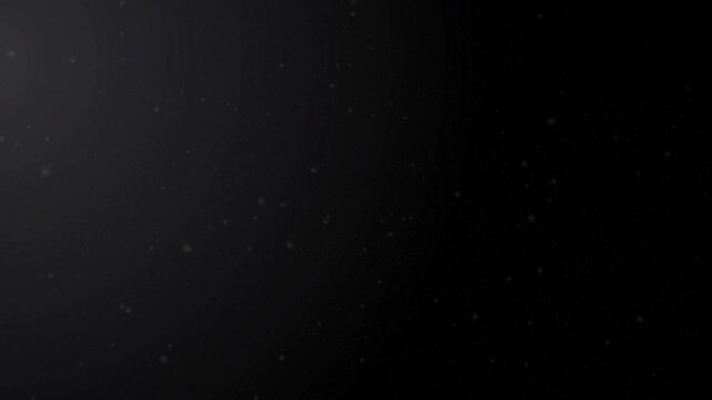 Cinematic floating specks in a dark studio setting with side lighting for overlay effects. Organic dust particles floating on black background