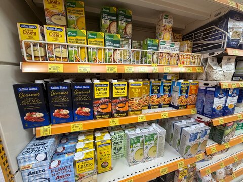 Calvia, Spain - June 07, 2026: Assorted food packaging on supermarket shelves featuring Gallina Blanca, Knorr, and various broth and seasoning products in a grocery store aisle