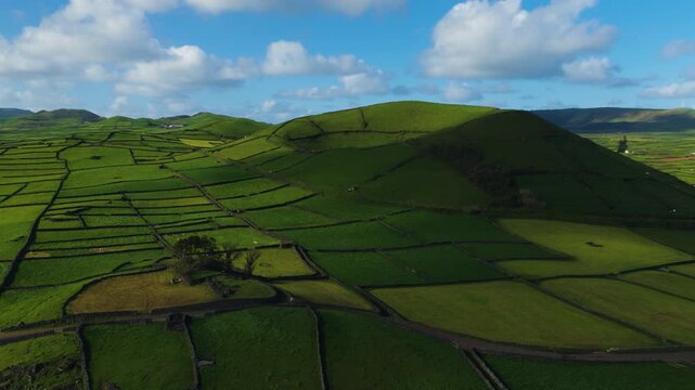 Terceira Island, Azores, Portugal - Rolling Green Fields and Pasturelands Surround Pico Dona Joana Beneath Scattered Clouds and a Bright Blue Sky - Aerial Drone Shot
