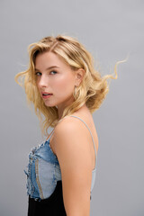 Naklejka premium Elegant blonde woman embodies chic denim fashion in modern setting