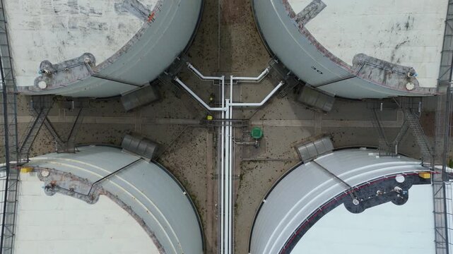 Aerial view of large liquified natural gas storage tanks and complex industrial piping at the LNG terminal in Isle of Grain, England, United Kingdom.