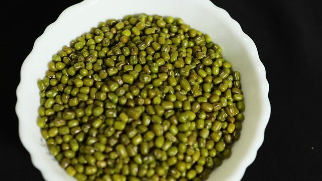 whole green gram legumes arranged in ceramic bowl for nutrition concept close up