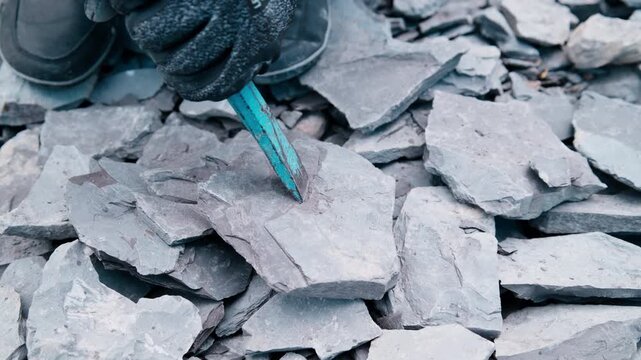 Handheld shot: chisel splits Jurassic Posidonia shale in Holzmaden, Germany. The thrill of fossil hunting &ndash; every strike could reveal an ammonite hidden for 180 million years.