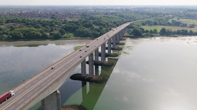 Drone Aerial Establishing of Vehicles and Truck Traffic Crossing Large Concrete Highway Bridge Over River Orwell UK