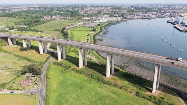 Drone Aerial High Angle of Vehicles Crossing Orwell Bridge in Ipswich Suffolk with River and City Background UK United Kingdom
