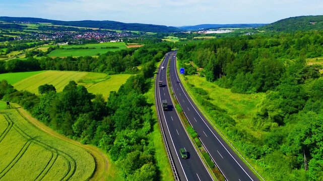 Aerial view of autobahn through forest and farmland with rural village in Germany