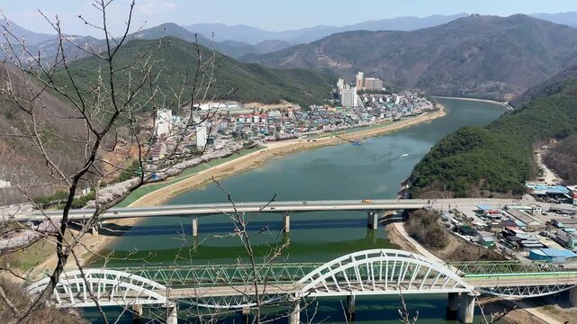 Panoramic view of Danyang and the Namhan River captured from Mancheonha Skywalk, featuring mountains, bridges, and a scenic riverside landscape.
