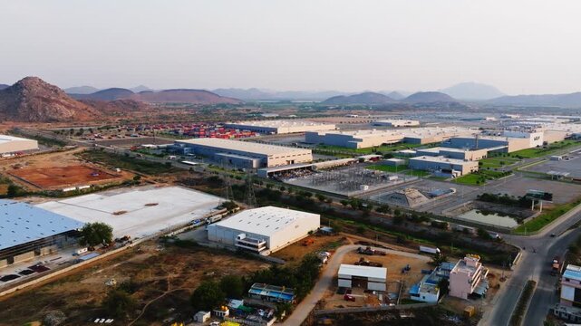 Aerial view of Kia manufacturing unit with Hyundai Steel manufacturing unit and mountains at Penukonda, Munimadugu, Anantapur, andhra pradesh, india. day time, semi orbit shot, drone shot, 4k.