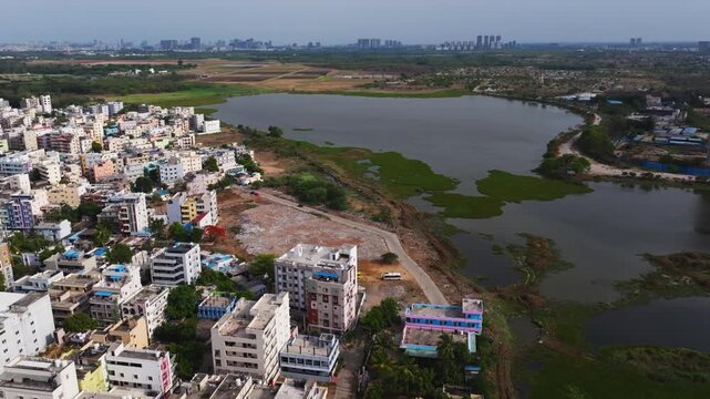 Patancheruvu Lake with residential buildings, Bus Station building and National highway 65 at patancheruvu, hyderabad, telangana, india. day time, semi circle shot, drone shot, 4k.