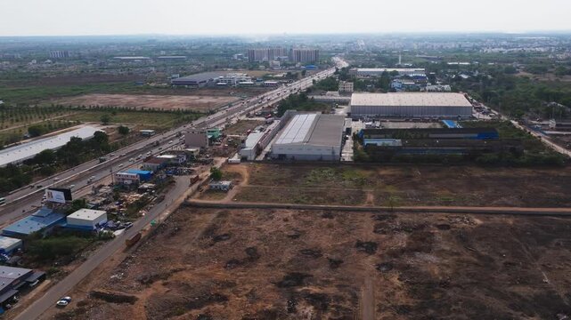 Hyderabad to solapur highway with traffic flow, dry land, buildings and warehouses at patancheruvu, hyderabad, telangana, india. day time, push in shot, drone shot, 4k.