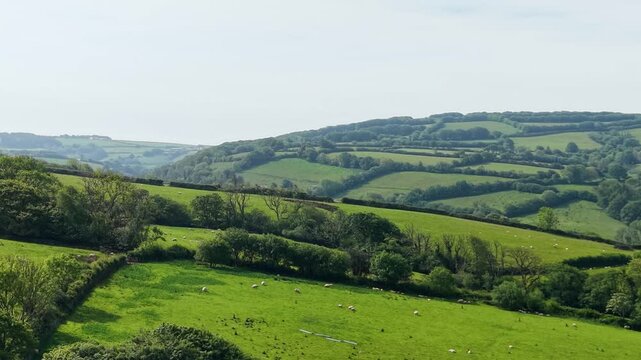 Rising Aerial of Countryside Fields with Parallax Effect with Multiple Hills and Winding Valleys in South West England Countryside. 4K.