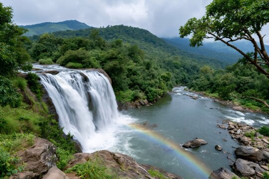 Athirappilly Waterfalls flowing into river creating rainbow