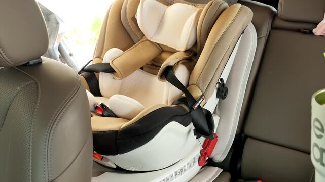 A person engages with an infant car seat in a vehicle's backseat, ensuring proper setup. Useful for parenting tutorials and child safety guides.